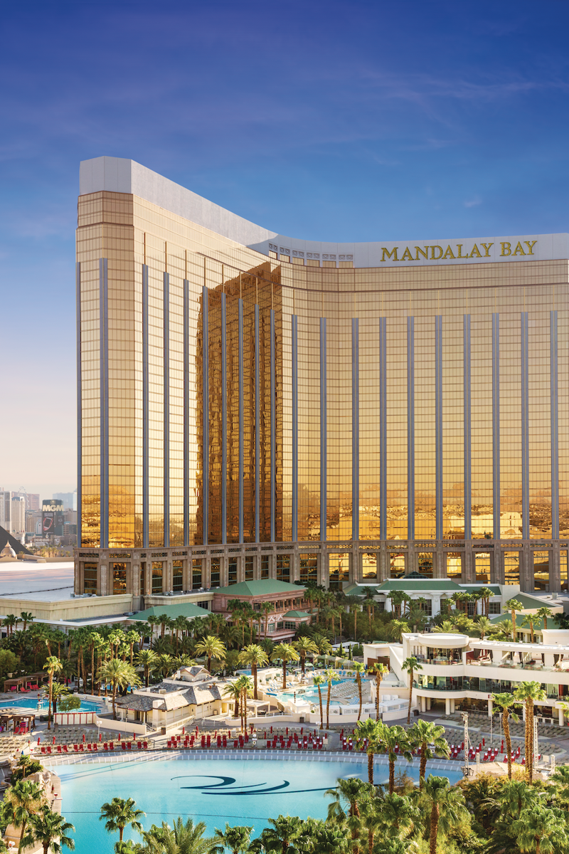 a large building with a pool in front of it with Mandalay Bay in the background
