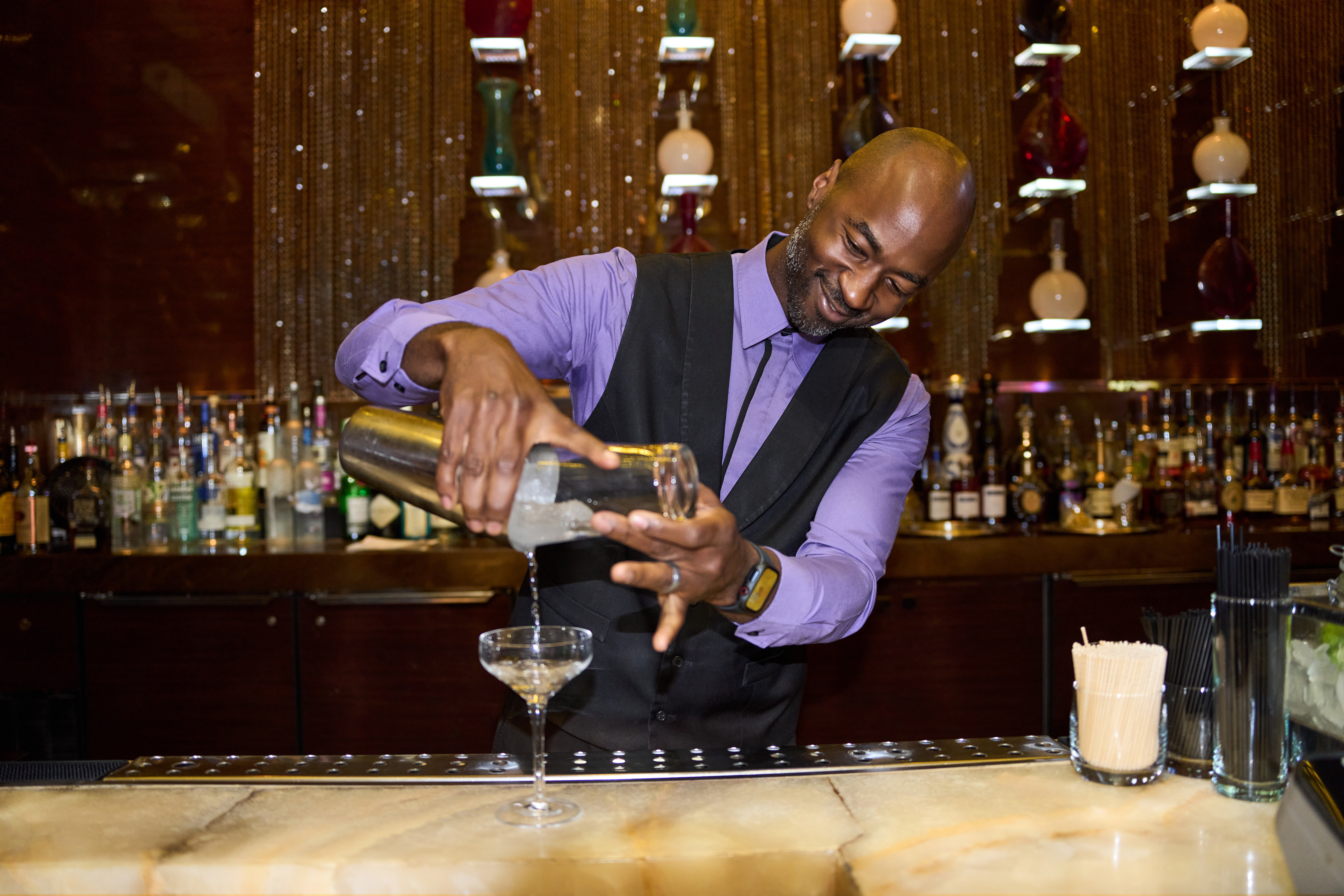 a person pouring a drink into a glass