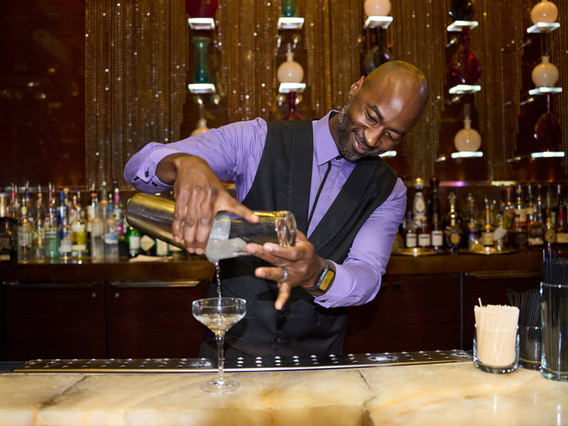a person pouring a drink into a glass