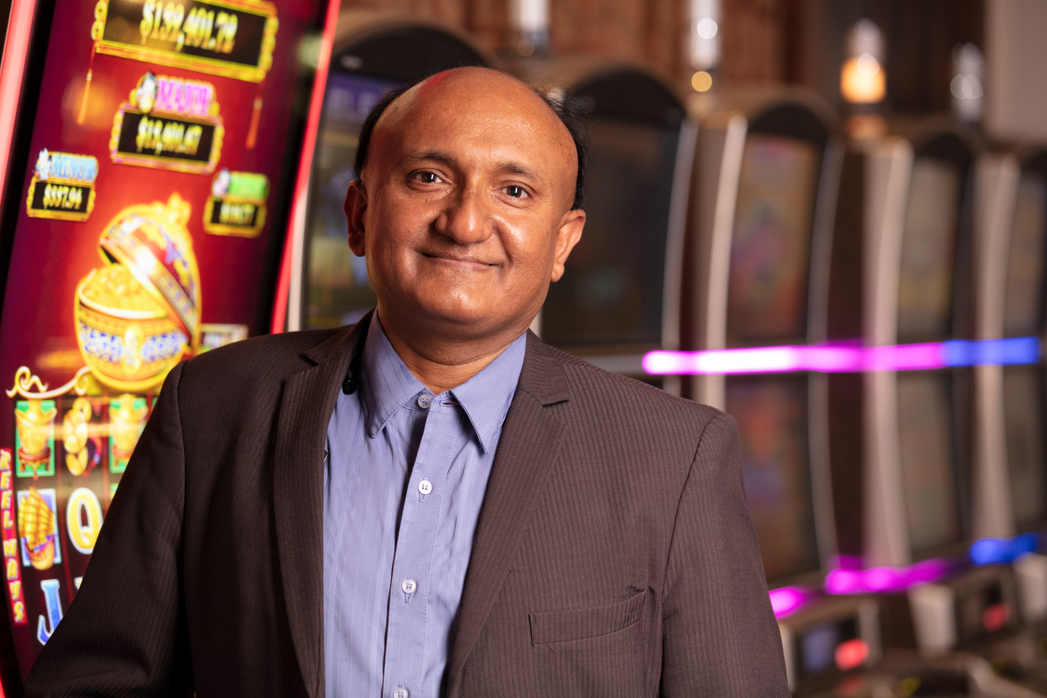 a person in a suit standing in front of slot machines