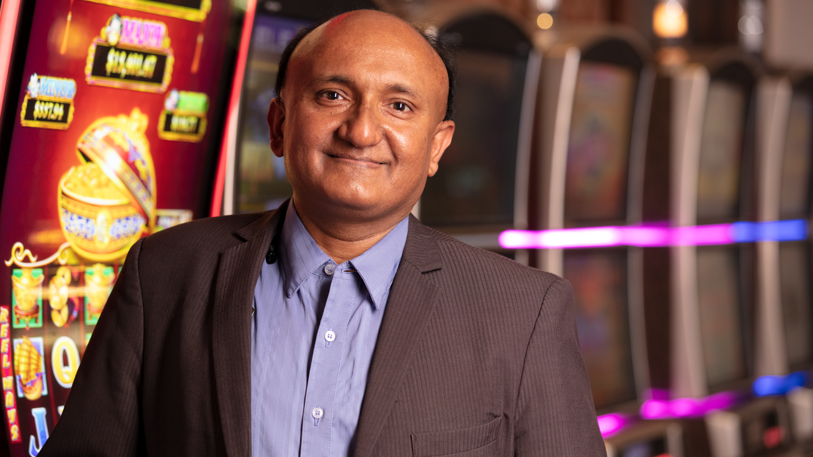 a person in a suit standing in front of slot machines