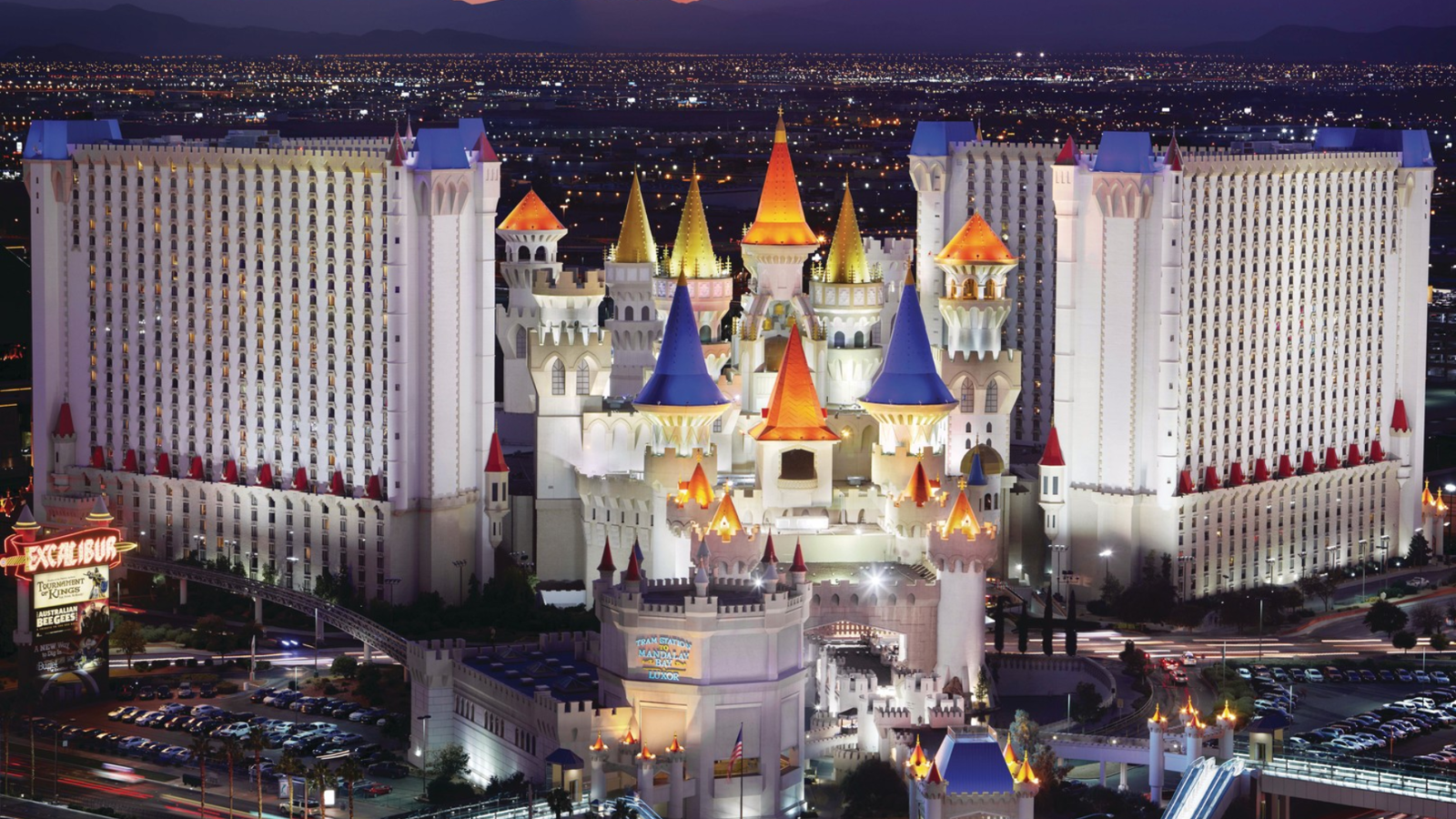 a large white castle with colorful towers with Excalibur Hotel and Casino in the background