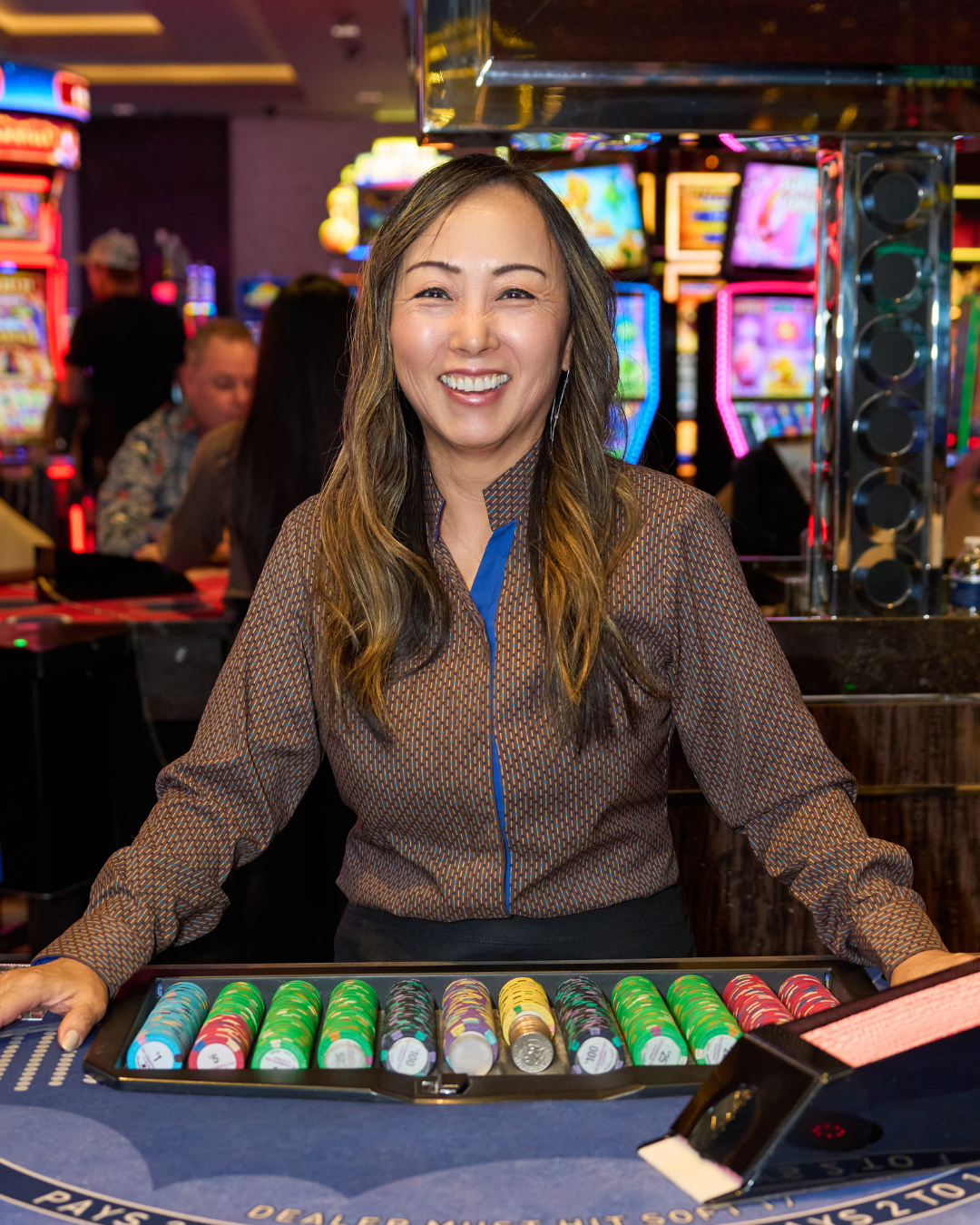a person standing behind a table with a casino chips
