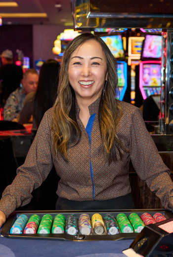 a person standing behind a table with a casino chips