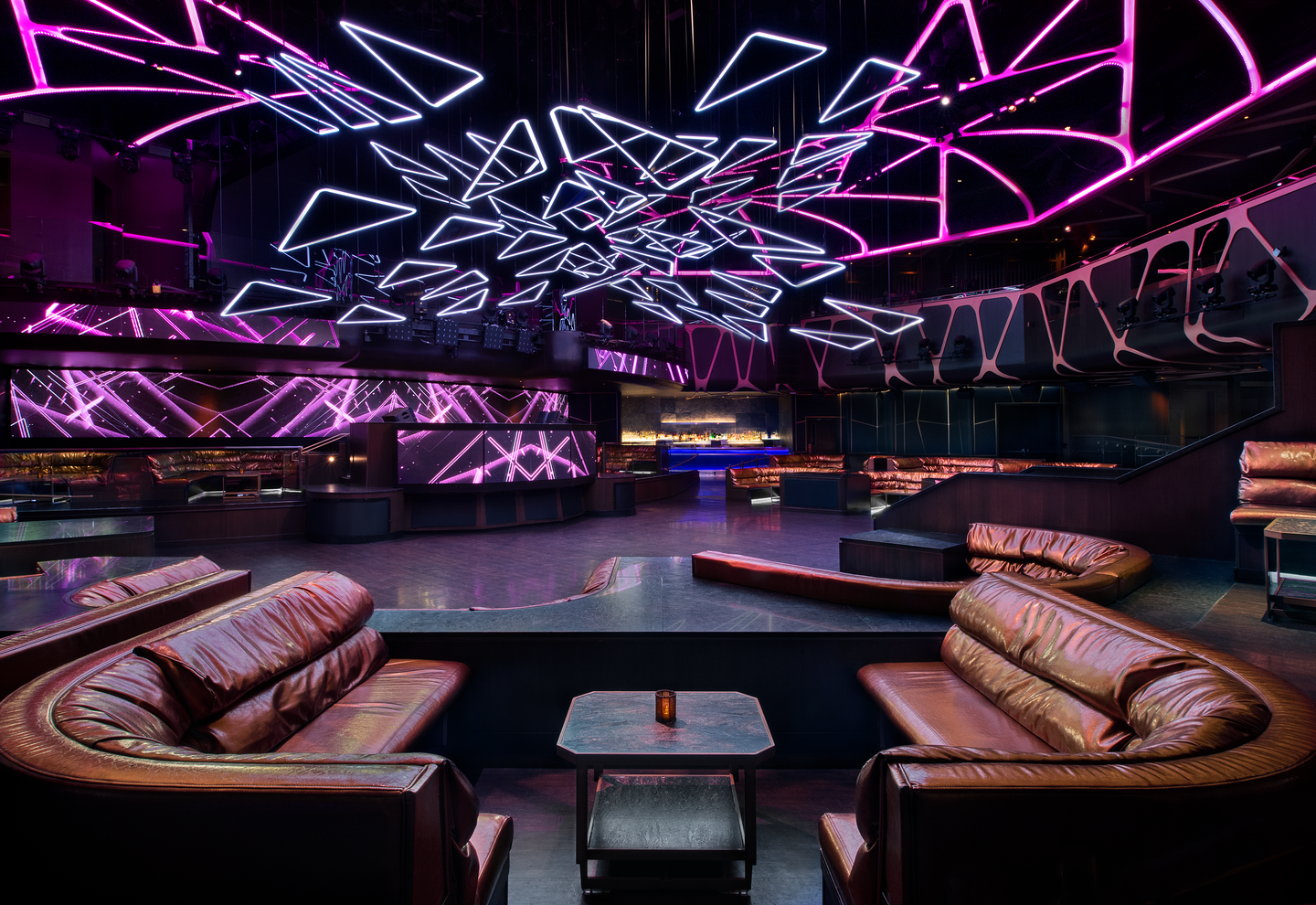 a room with leather couches and purple lights