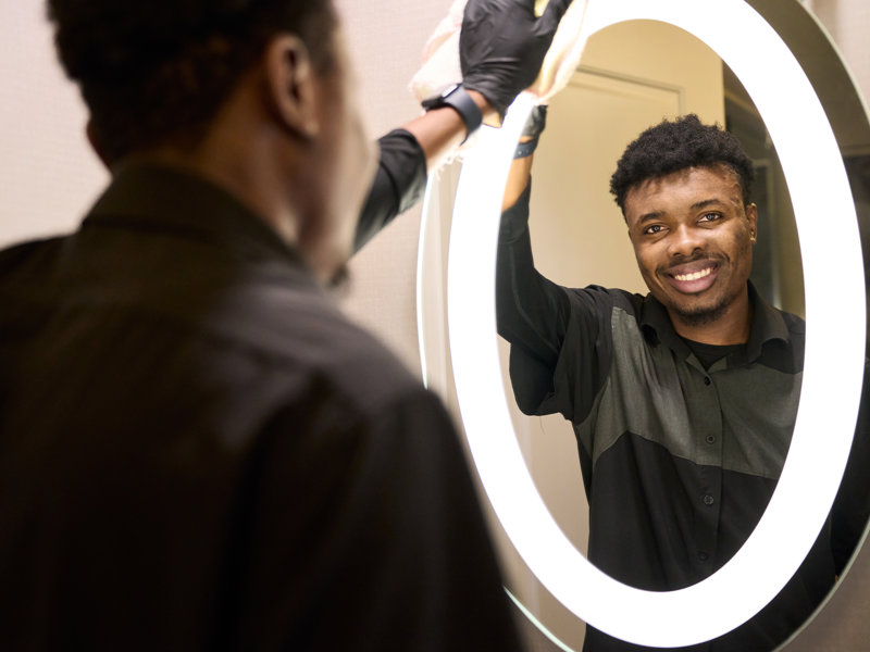 a person cleaning a mirror