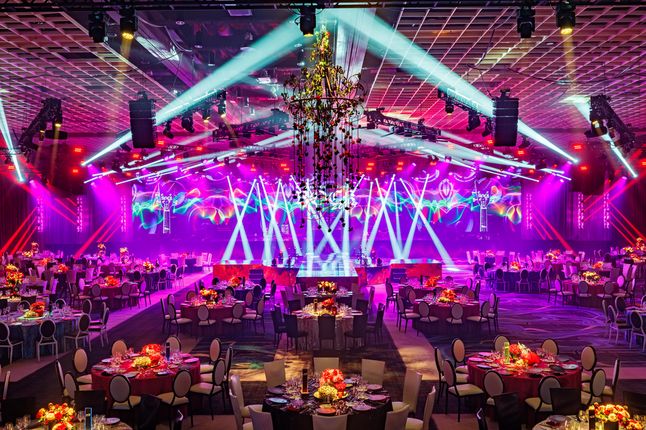 a large room with tables and chairs and purple lights