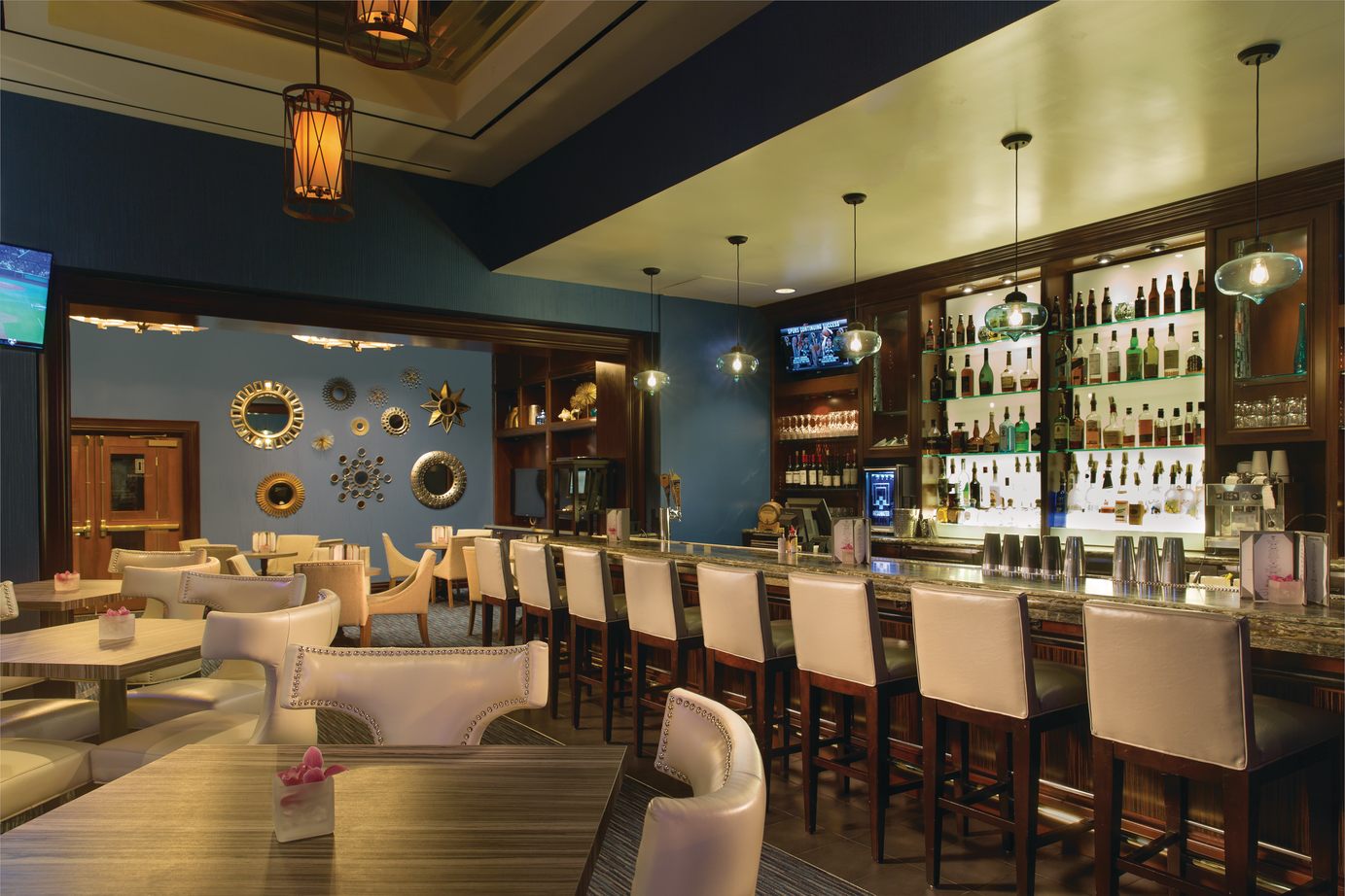 a bar with white chairs and tables