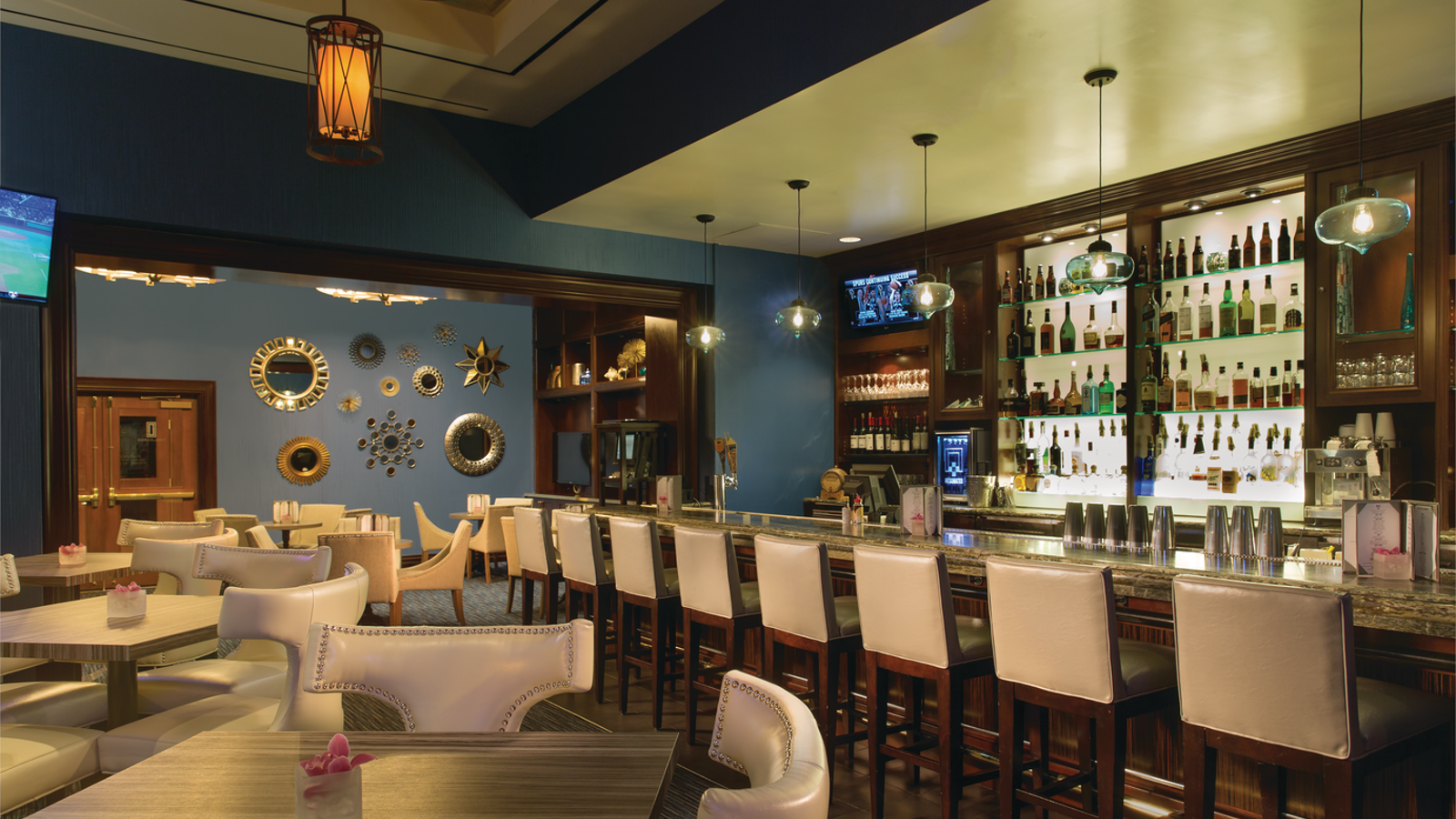 a bar with white chairs and tables