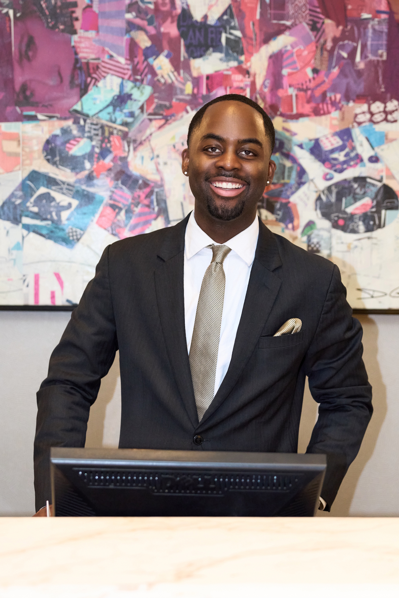 a person in a suit standing behind a computer