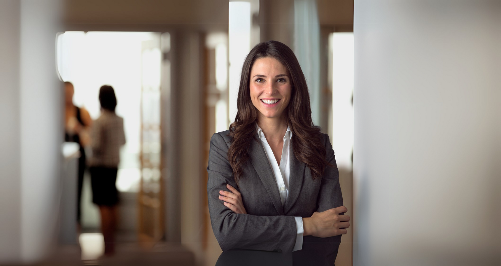 a person in a suit standing with her arms crossed
