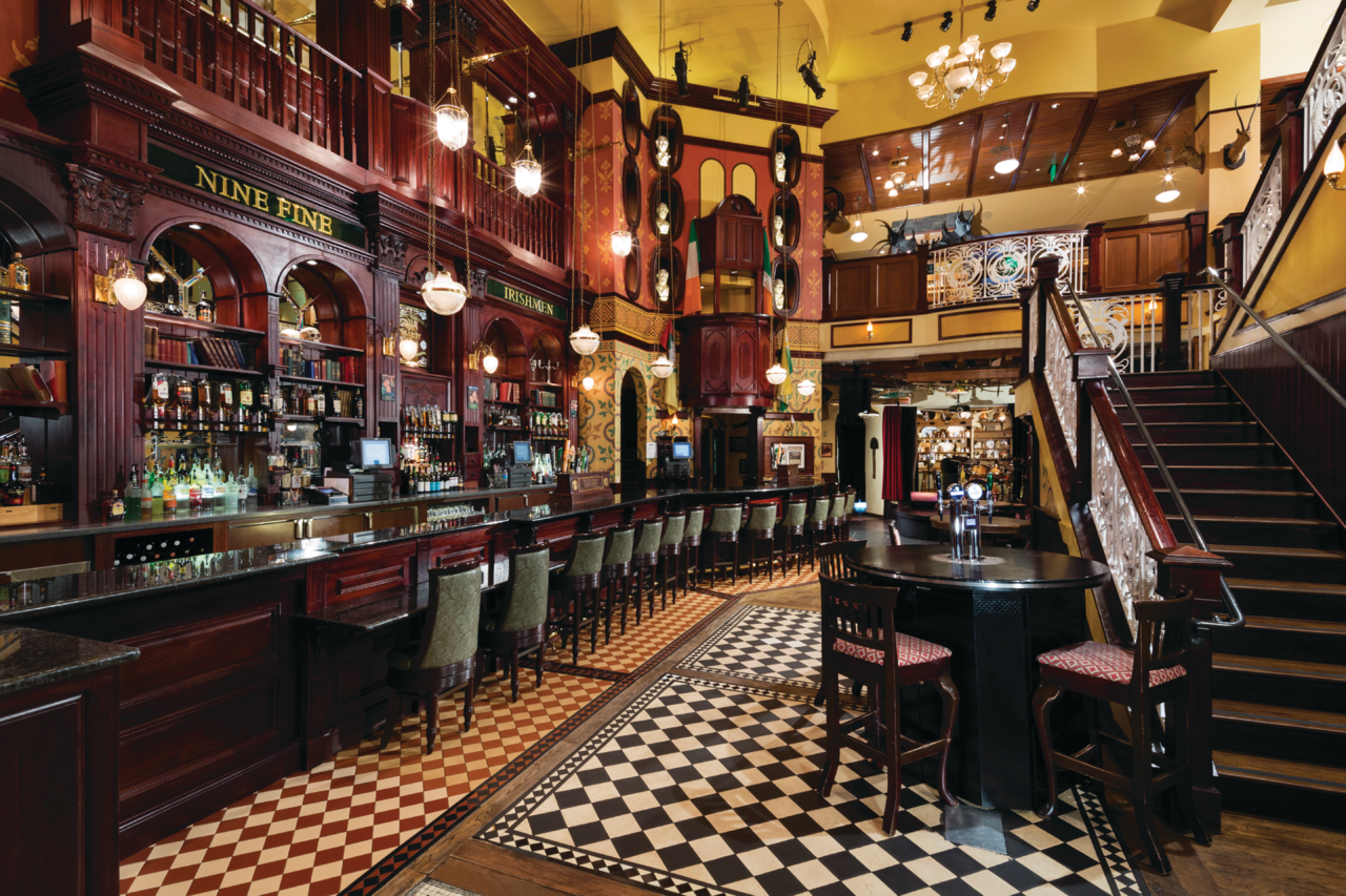 a bar with a black round table and chairs