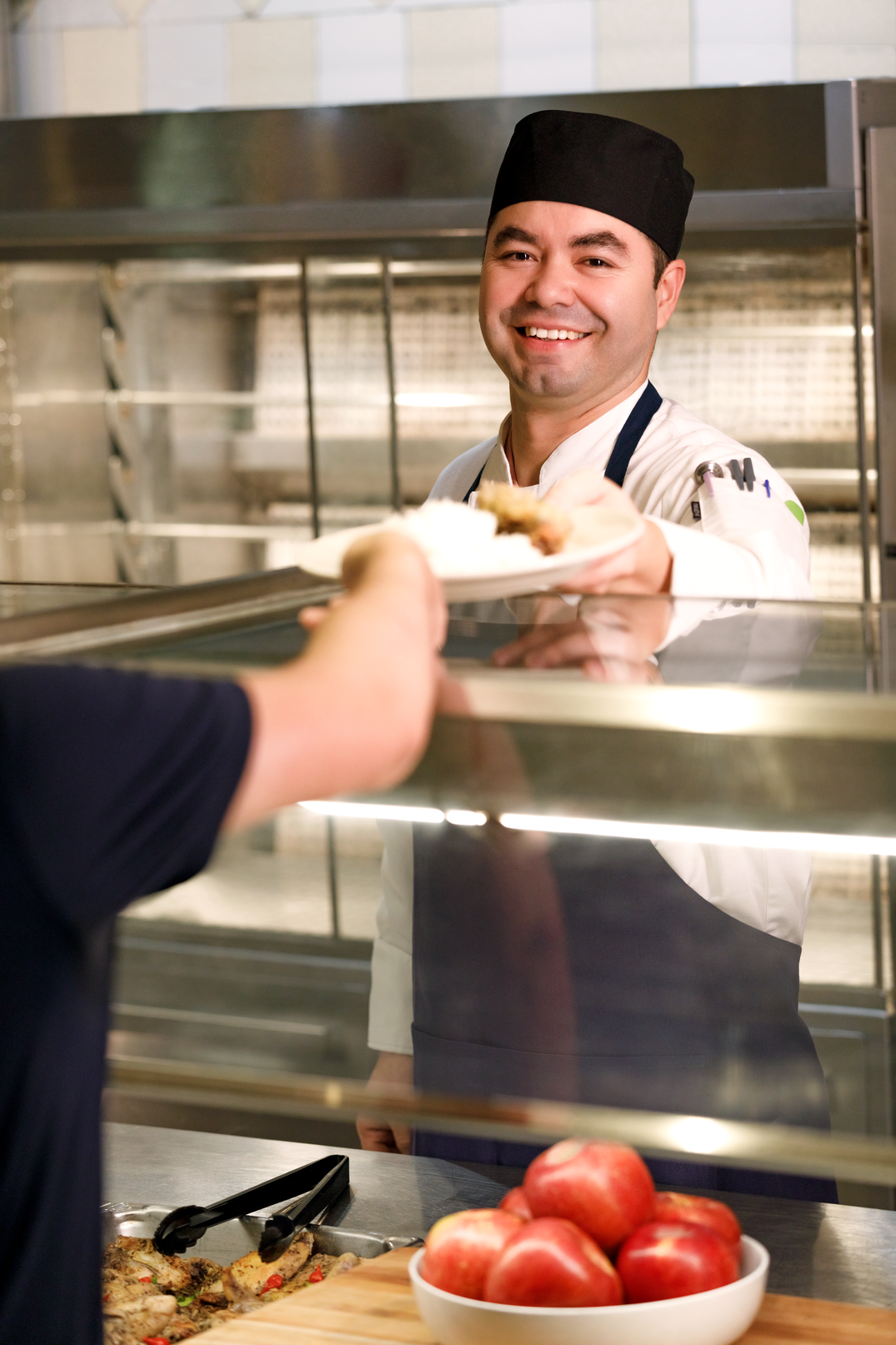 a person handing a plate of food to a customer