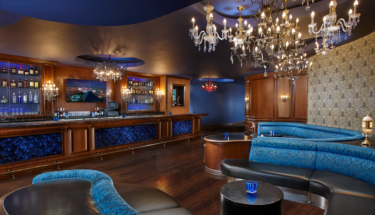 a room with a bar and a chandelier