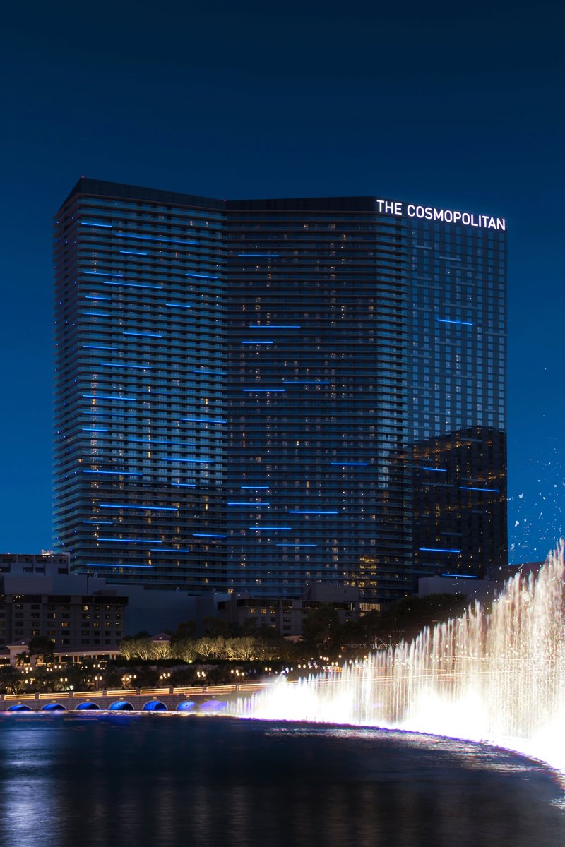a water fountain with a lit up building in the background