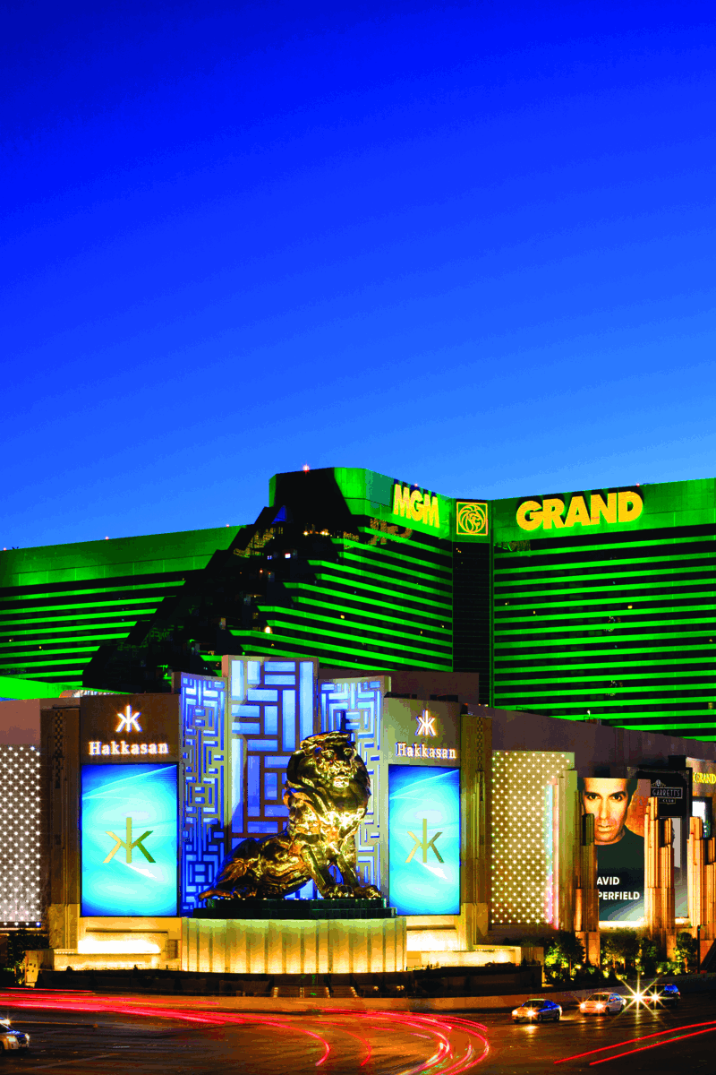 a large building with green lights with MGM Grand Las Vegas in the background