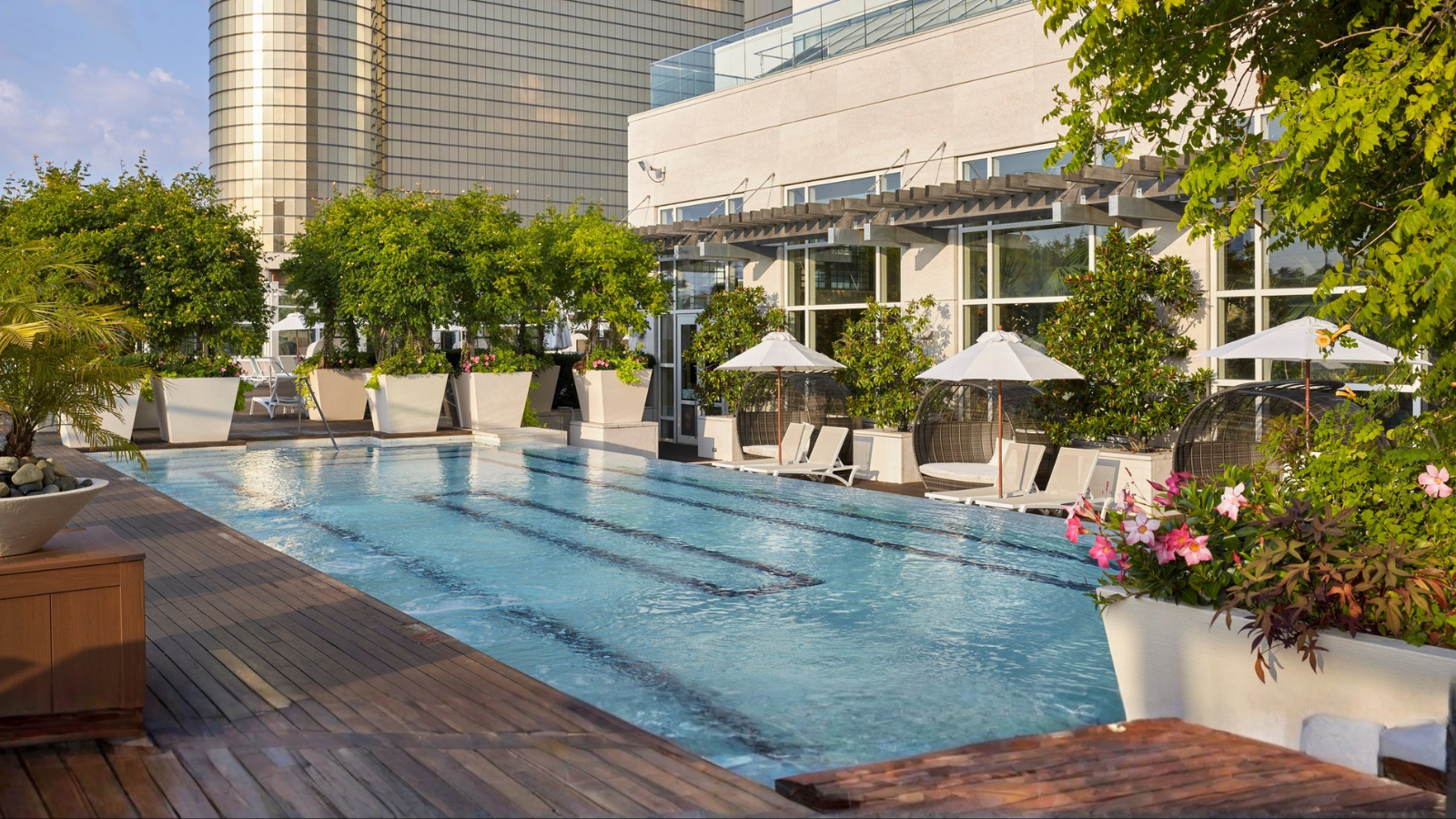 a swimming pool with umbrellas and chairs in front of a building