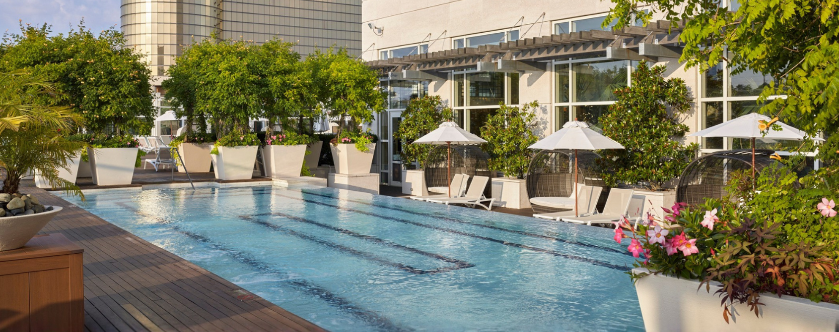 a swimming pool with umbrellas and chairs in front of a building