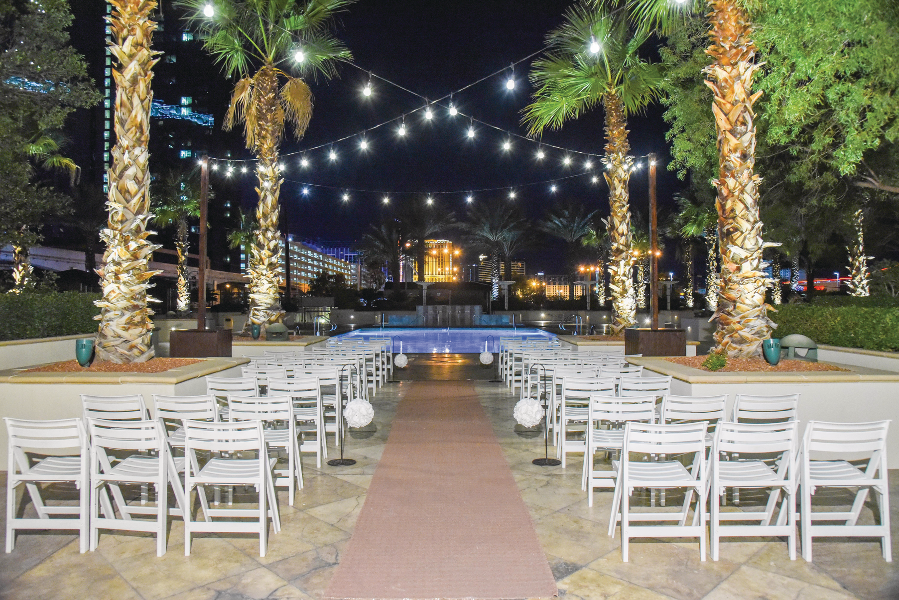 a pool with palm trees and chairs