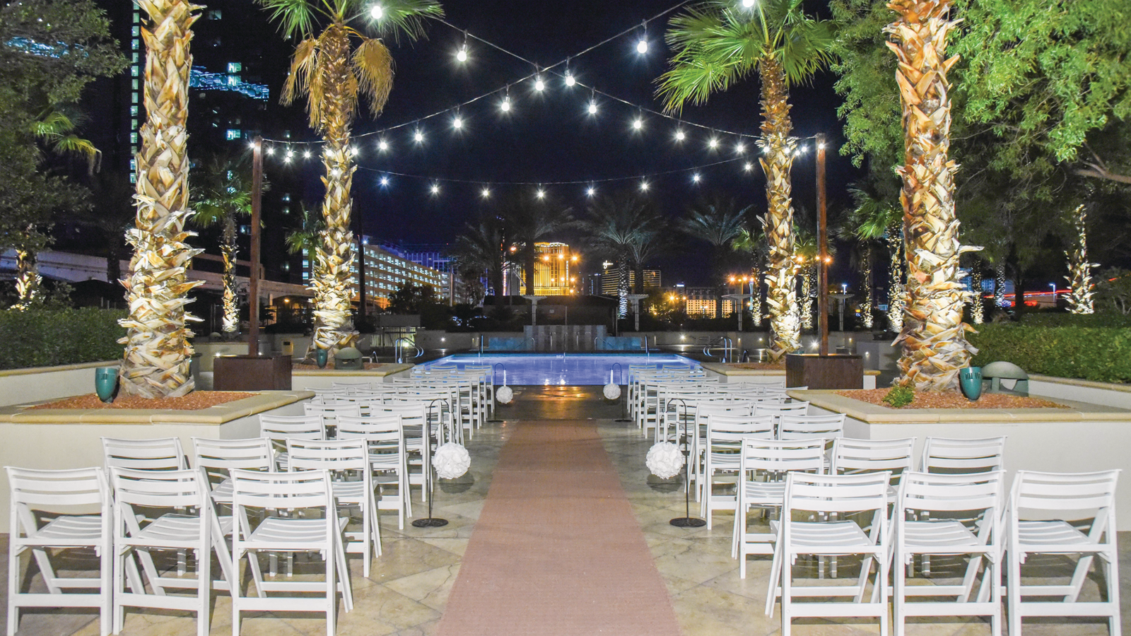 a pool with palm trees and chairs