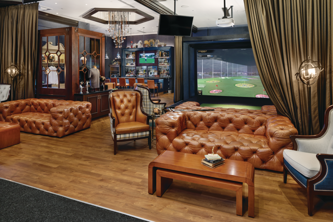 a room with leather couches and a large screen