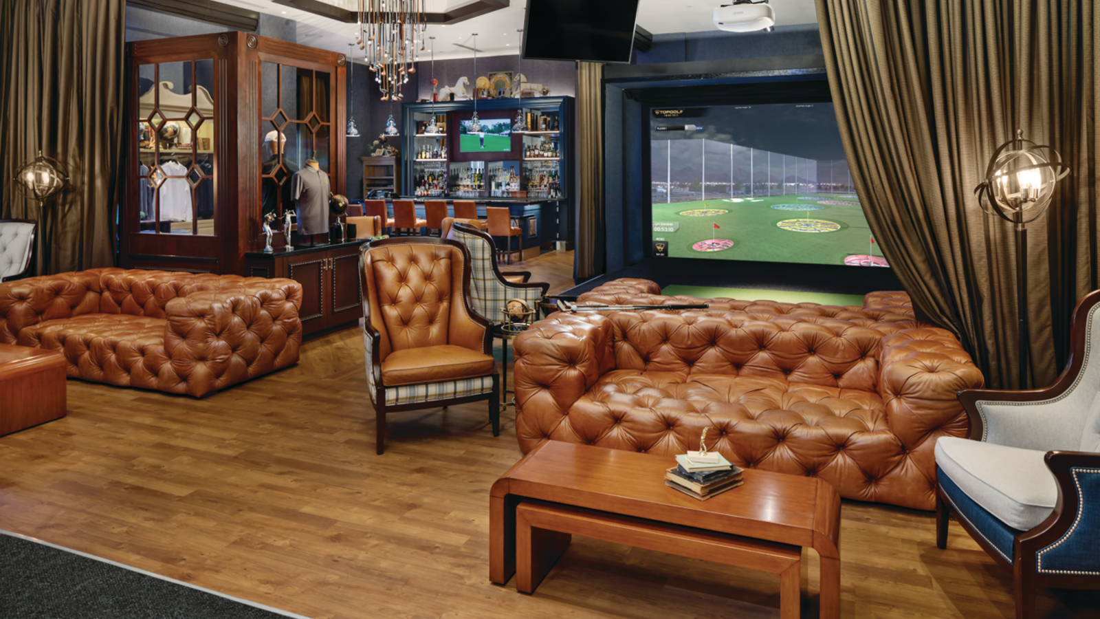 a room with leather couches and a large screen