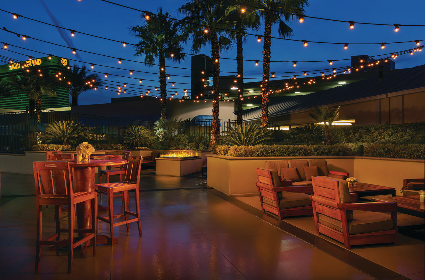 a patio with chairs and tables and lights