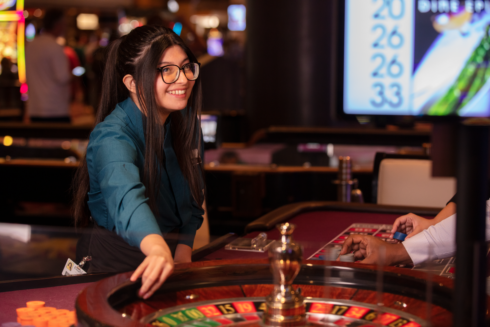 a person smiling at a roulette table