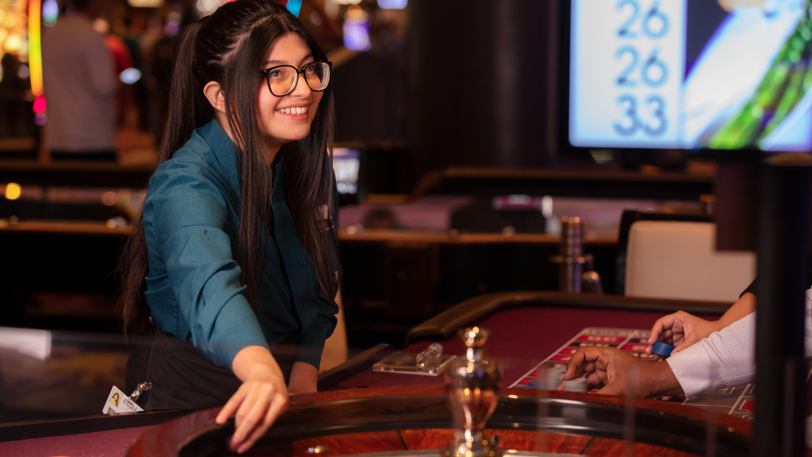a person smiling at a roulette table