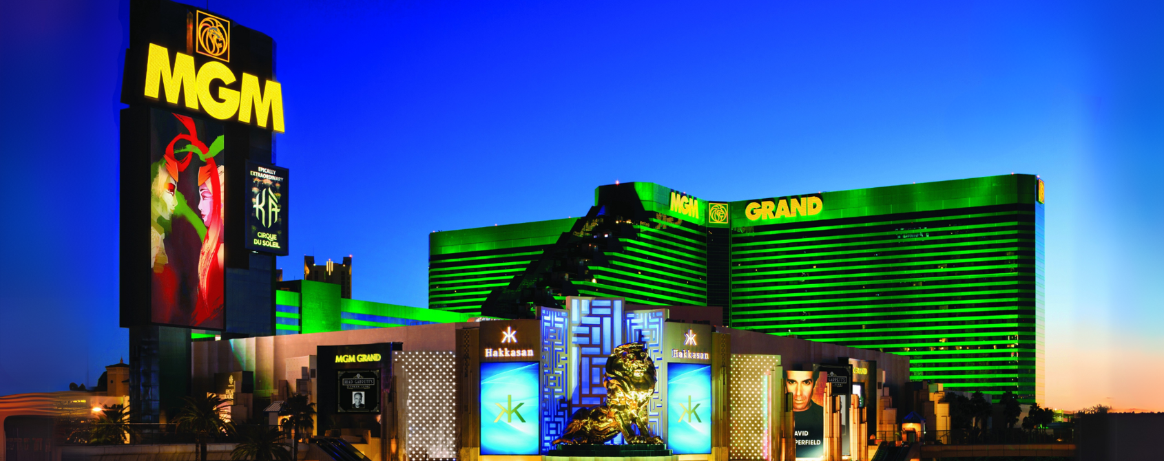 a large building with green lights with MGM Grand Las Vegas in the background
