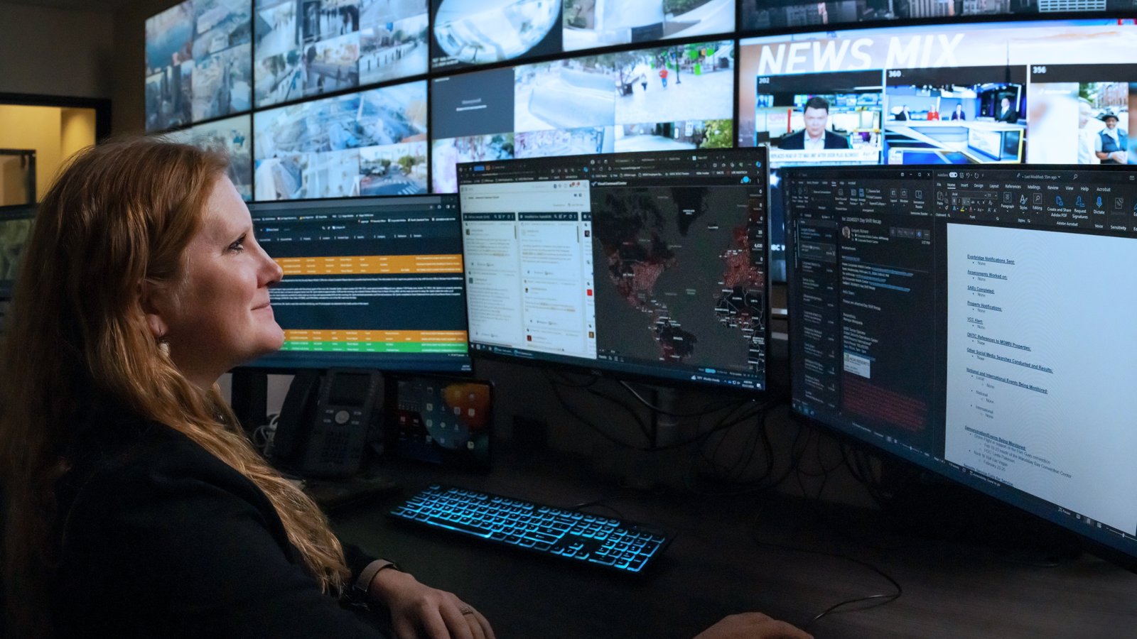 a person sitting in front of multiple screens