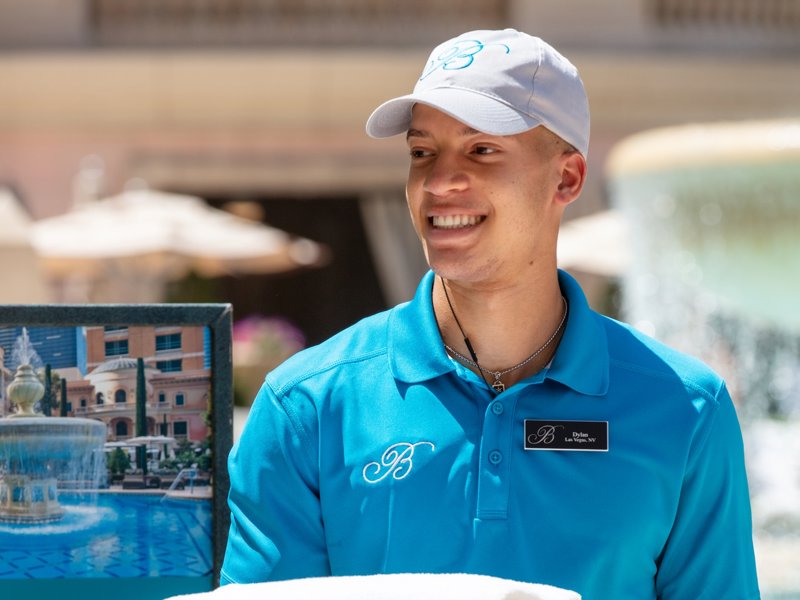 a person holding towels in front of a sign