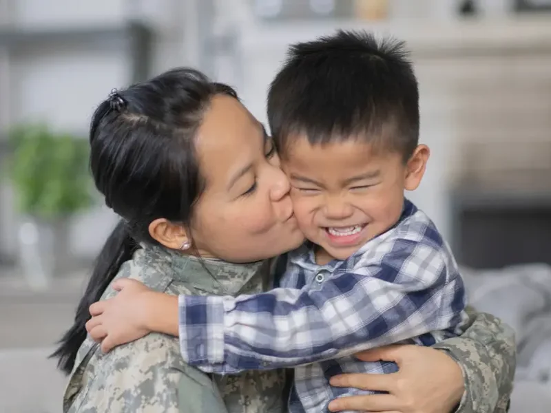 a person kissing a child's cheek