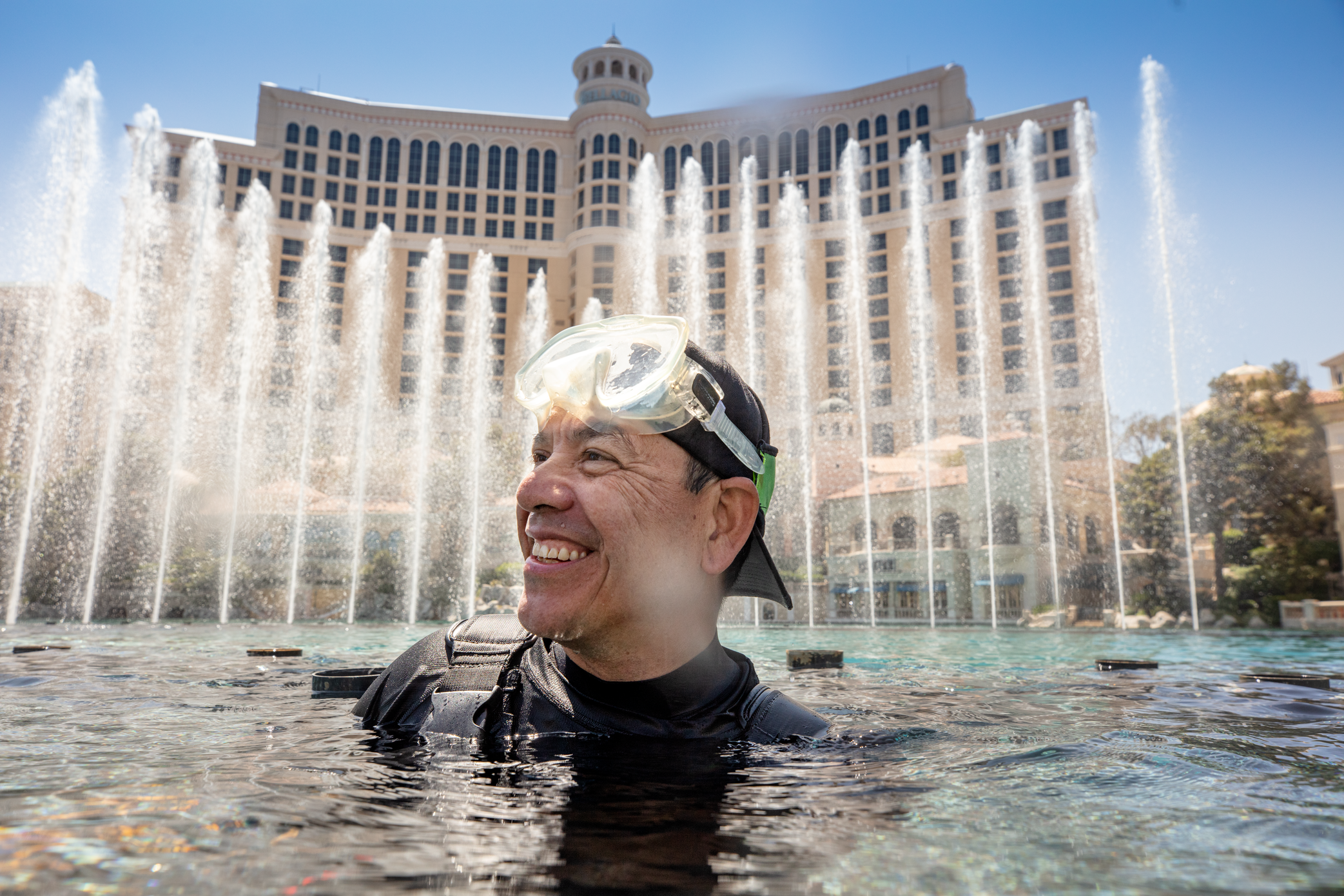 a person in water with goggles in front of a fountain